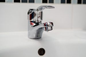 Image is a bathroom faucet that is left dripping.