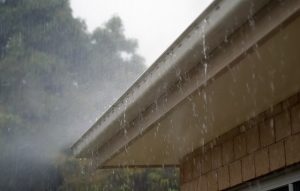 Image is a rain gutter on a home overflowing. Image is a rain gutter on a home overflowing.